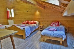 a bedroom with two beds in a log cabin at Chalet Le Plan du Rtia in Morzine