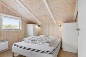 a bed in a room with a wooden ceiling at LN1954-Hirtshals-Harestien-27 in Hirtshals