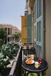 ein Tisch mit einem Teller Essen auf einem Balkon in der Unterkunft Hotel Nap By HappyCulture in Nizza