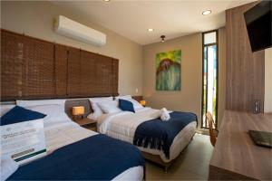 a hotel room with two beds and a television at Stella club & resort in Hacienda La Cabaña