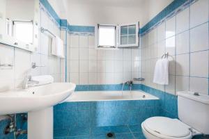 a blue and white bathroom with a tub and a toilet at Villa Zeus in Spartià +22 photos