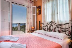 a bedroom with a bed with a view of the ocean at Villa Zeus in Spartià
