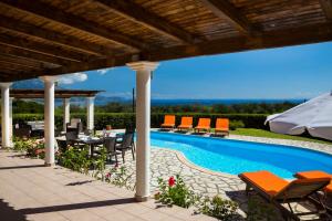 a patio with a table and chairs next to a swimming pool at Villa Zeus in Spartià