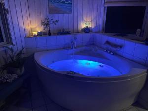 a large blue tub in a bathroom at night at LN1951-Hirtshals-Klitrenden-1 in Hirtshals