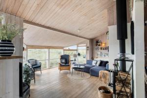 a living room with a blue couch and a tv at LN1951-Hirtshals-Klitrenden-1 in Hirtshals