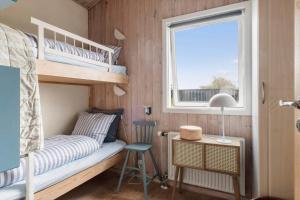 a small bedroom with bunk beds and a window at LN1951-Hirtshals-Klitrenden-1 in Hirtshals