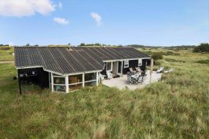 a house with a deck in the middle of a field at LN1951-Hirtshals-Klitrenden-1 in Hirtshals