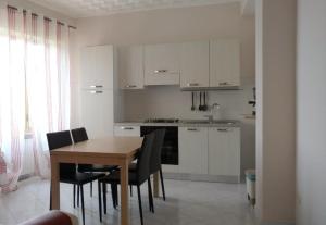 a kitchen with a table and chairs and a kitchen with white cabinets at Sant'Agostino Apartment in Catanzaro
