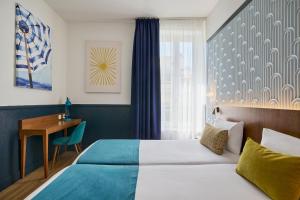 ein Hotelzimmer mit Bett und Schreibtisch in der Unterkunft Hotel Nap By HappyCulture in Nizza