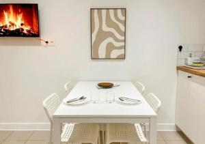 a white table and chairs in a kitchen with a fireplace at Doux Pavillon - Sauna - Jacuzzi in Tassin-la-Demi-Lune +13 photos