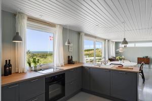 a kitchen with gray cabinets and a large window at LN1938-Hirtshals-Kranken-9 in Hirtshals