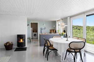 a kitchen and dining room with a table and a fireplace at LN1938-Hirtshals-Kranken-9 in Hirtshals +16 photos