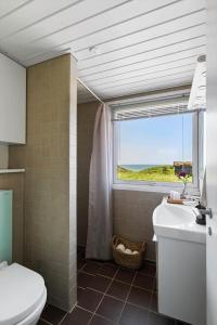 a bathroom with a toilet and a window and a sink at LN1938-Hirtshals-Kranken-9 in Hirtshals