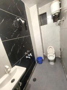 a bathroom with a white toilet and a sink at Hotel Gareen By Du Rooms Near Delhi University Kamlangar in New Delhi