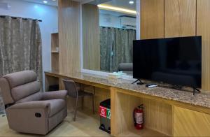 a room with a flat screen tv and a chair at Yuhum Boracay Suites in Boracay +8 photos