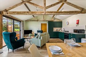 a kitchen and living room with green cabinets and a wooden table at Shippon 1 in Radley