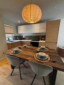 a kitchen with a wooden table with two chairs at Zilt en Zen Zeeland in Bruinisse