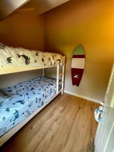 a bedroom with a bunk bed with a surfboard on the wall at Zilt en Zen Zeeland in Bruinisse +13 photos