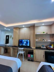 a hotel room with two beds and a flat screen tv at Yuhum Boracay Suites in Boracay