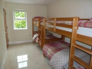 a room with three bunk beds and a window at Ballyvoy Camping Barn in Willenhall