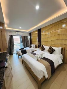 a hotel room with two beds and a television at Yuhum Boracay Suites in Boracay