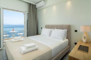 a bedroom with a bed with two towels on it at Aeloria Boutique Hotel Corfu in Benitses +37 photos