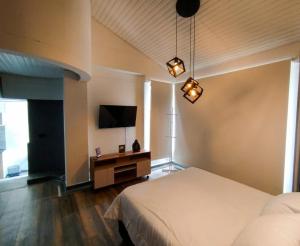 a bedroom with a bed and a tv on the wall at Textileria in Pereira