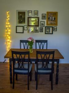 a dining room table with two chairs and a vase of flowers at Apartament Antracytowe Wrota 3 in Boguszów-Gorce