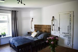 a bedroom with a bed and a vase of flowers at Apartament Antracytowe Wrota 3 in Boguszów-Gorce