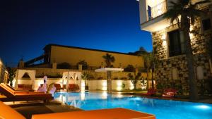 a swimming pool in front of a building at night at Canata Çeşme in Çeşme +93 photos