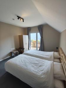 a bedroom with a large white bed and a window at Alpenhaus Claudia in Radenthein