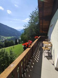 a balcony of a house with chairs and flowers at Alpenhaus Claudia in Radenthein