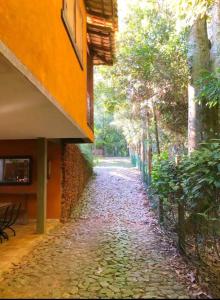 a cobblestone alley with trees and a building at Zíngara - Kombi Home in Brumadinho