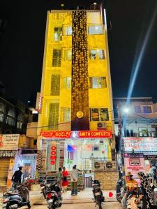 a tall yellow building with motorcycles parked in front of it at Amith Comforts near to Railway Station in Mysore
