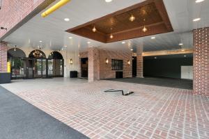 a lobby with a brick wall and a floor with a table at The Miners 1928 Hotel in Pottsville