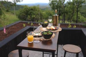 a table with glasses of wine and a plate of food at Ateliéry Nad Závozom in Hrušov