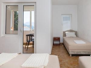 a room with two beds and a room with a table at Apartments Music in Sutomore