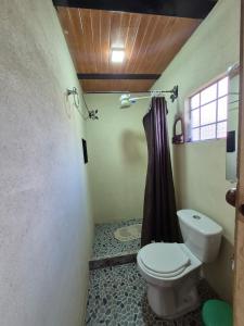 a bathroom with a toilet and a shower curtain at Rinconcito campesino in Aquitania +21 photos