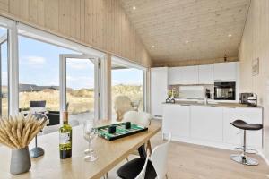 a kitchen and living room with a table and chairs at LN1865-Hirtshals-Krageklit-30 in Hirtshals