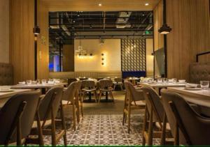 a dining room with tables and chairs and a stage at Hotel Elysian By G K Group Near IGI Delhi Airport in New Delhi