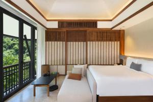 a bedroom with a large bed and a large window at Banyan Tree Cabo Marques in Acapulco