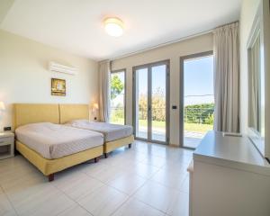 a bedroom with a bed and sliding glass doors at Villa Ilias in Skala +30 photos