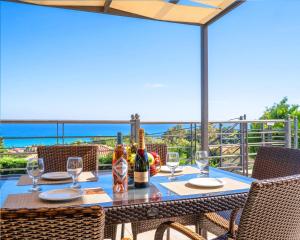 a table with wine bottles and glasses on a balcony at Villa Ilias in Skala