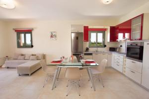 a kitchen and living room with a table and chairs at Trapezaki Bay Cottage in Trapezaki