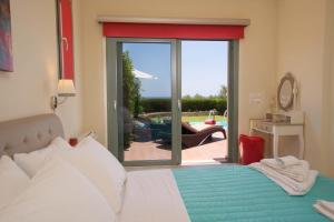 a bedroom with a bed and a sliding glass door at Trapezaki Bay Cottage in Trapezaki +6 photos