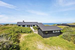 a house on a hill with the ocean in the background at LN1963-Hirtshals-Klynen-19 in Hirtshals