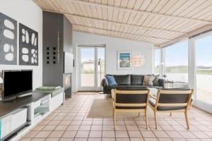 a living room with a couch and a tv at LN1963-Hirtshals-Klynen-19 in Hirtshals