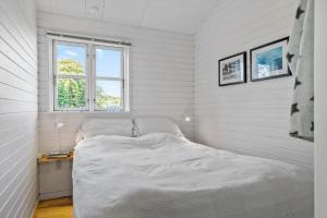 a bed in a white room with a window at LN1987-Hjorring-Havbruset-6 in Hjørring