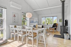 a dining room with a white table and chairs at LN1987-Hjorring-Havbruset-6 in Hjørring
