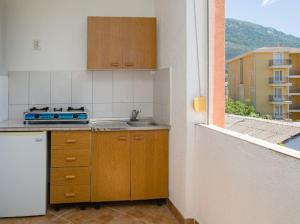 a small kitchen with a sink and a window at Apartments Music in Sutomore +33 photos